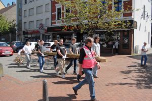 Da macht die Arbeit richtig Spaß. Freiwillige Junggesellen tragen den Maibaum zum Platz vor der Sparkasse Herbede.