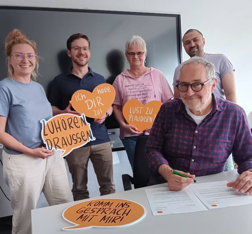 Wetters Bürgermeister Hans-Günter Draht unterzeichnet den Kooperationsvertrag für das Projekt „Zuhör.Bänke“: Mit dabei sind Simone Staufenberg, Caroline Janicki, Jannick Meyer und Anas Alhashmi vom frisch formierten „Team Zuhörzeit“. Foto: Stadt Wetter