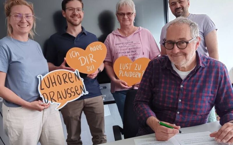 Wetters Bürgermeister Hans-Günter Draht unterzeichnet den Kooperationsvertrag für das Projekt „Zuhör.Bänke“: Mit dabei sind Simone Staufenberg, Caroline Janicki, Jannick Meyer und Anas Alhashmi vom frisch formierten „Team Zuhörzeit“. Foto: Stadt Wetter
