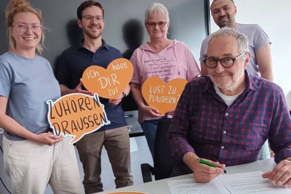 Wetters Bürgermeister Hans-Günter Draht unterzeichnet den Kooperationsvertrag für das Projekt „Zuhör.Bänke“: Mit dabei sind Simone Staufenberg, Caroline Janicki, Jannick Meyer und Anas Alhashmi vom frisch formierten „Team Zuhörzeit“. Foto: Stadt Wetter